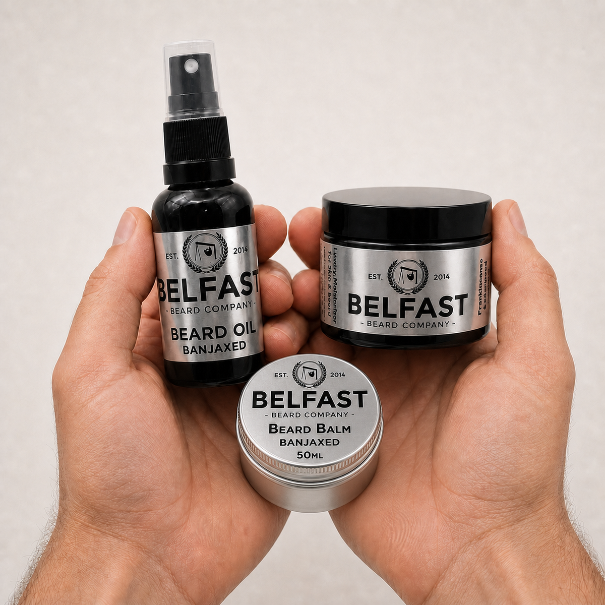 Beard Balm, Oil and Luxury Moisturiser Combo held in a hand to show its size